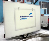 Verkaufshänger für Fischerzeugnisse - Verkaufshänger mit großer Seitenklappe. Zur Grundaustattung gehören eine<br />
durchgehende Arbeitsfläche mit Hygienepaket, Elektroinstalltion 16Ah, Beleuchtung und Steckdosen sowie ein Vorratsschrank für Reinigungsmittel und Zubehör.<br />
Durch Verwendung des Wabenverbundstoffes Monopan® für den Kofferaufbau kann das Gesamtgewicht für den Hänger extrem niedrig gehalten werden.<br />
Infolge der Lichtdurchlässigkeit des Monopan herrscht eine angenehme und helle Arbeitsatmosphäre. <br />